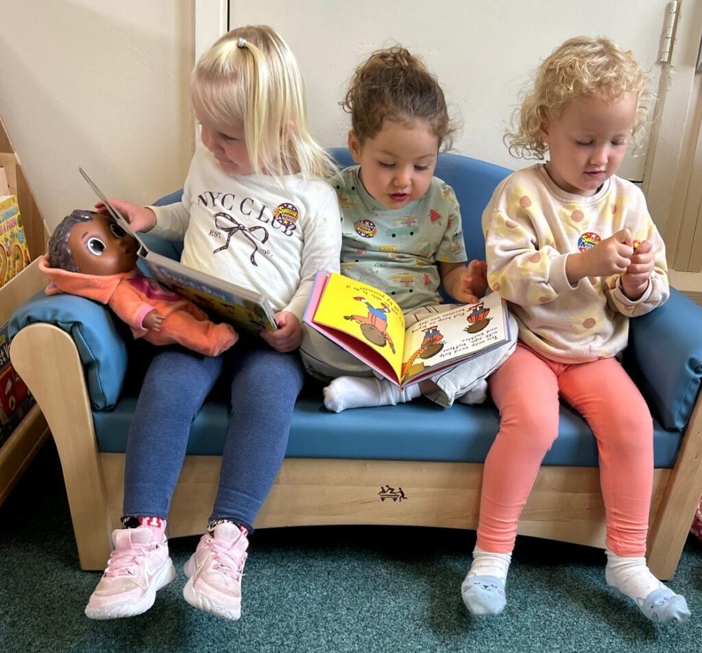 Nursery children sharing books together