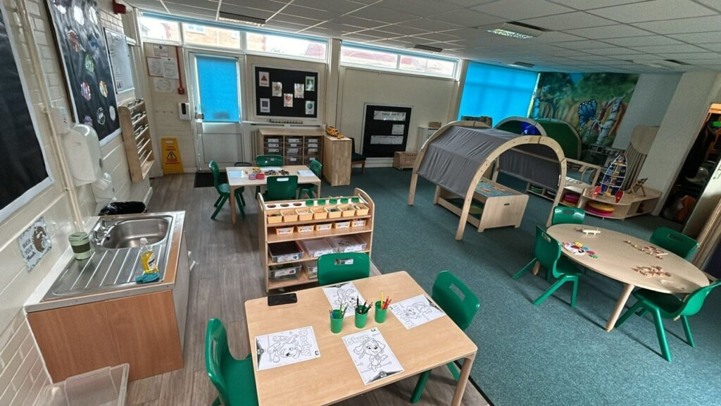Inside the nursery classroom with tables and learning areas