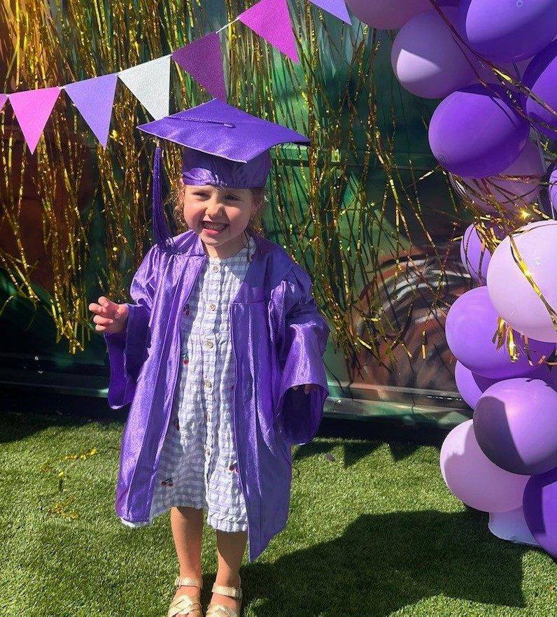 A nursery child at their graduation celebration